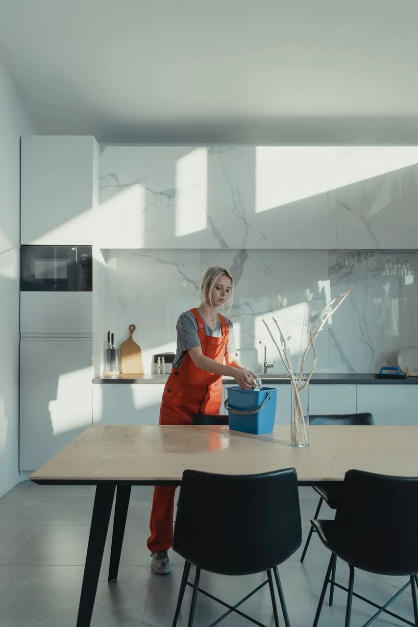 Professional cleaner working in a bright modern kitchen
