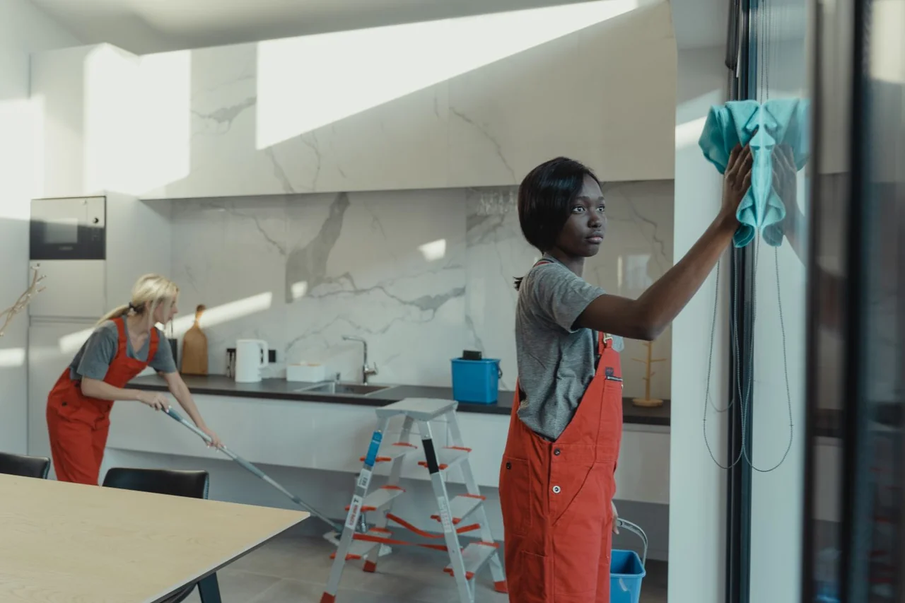 Cleaning professionals sanitizing a modern kitchen